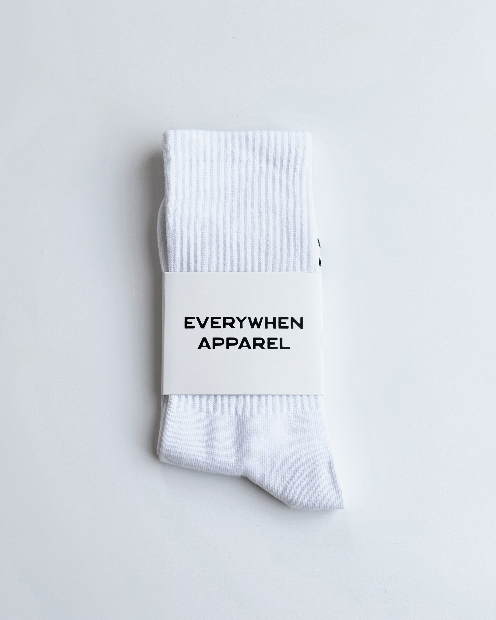 White socks with 'EVERYWHEN APPAREL' label on a light gray background